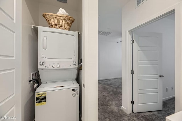 laundry room with dark carpet and stacked washer and dryer