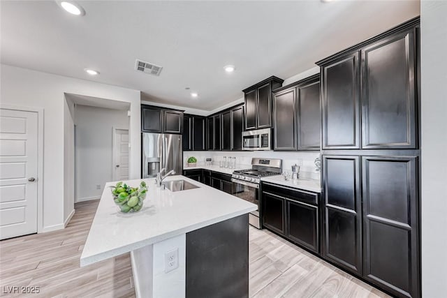 kitchen featuring stainless steel appliances, light countertops, visible vents, and a sink