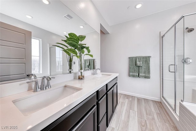 full bath featuring a stall shower, a sink, and visible vents