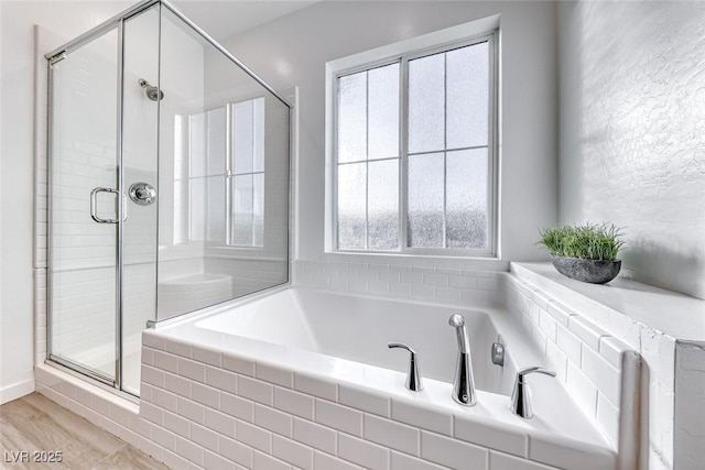 full bath with a garden tub, wood finished floors, and a shower stall