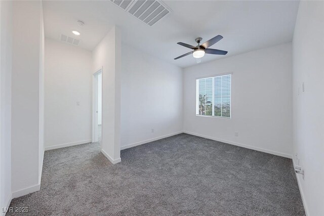 carpeted spare room with ceiling fan, visible vents, and baseboards