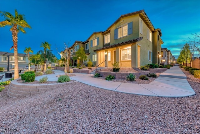 exterior space featuring a residential view, a tile roof, and stucco siding