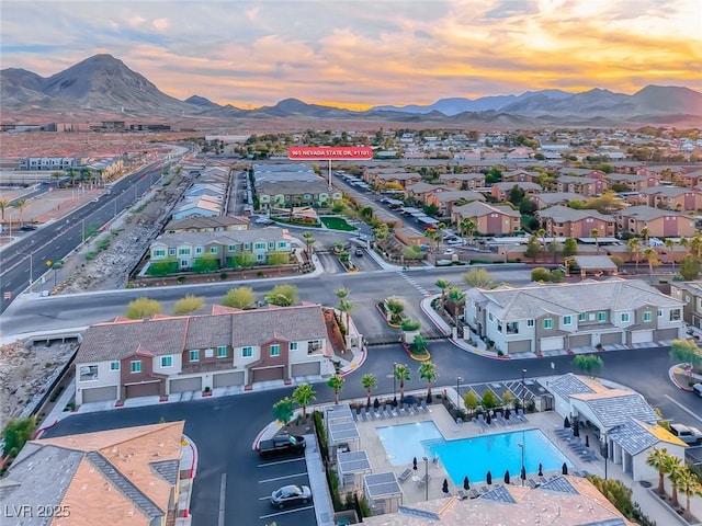 aerial view at dusk featuring a residential view and a mountain view