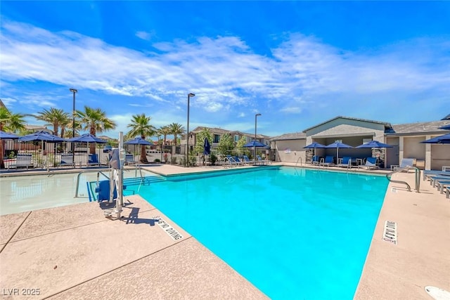 pool featuring a patio, fence, and a residential view