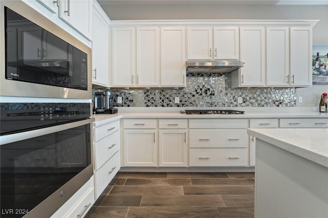 kitchen featuring white cabinetry, black microwave, tasteful backsplash, stainless steel oven, and gas cooktop