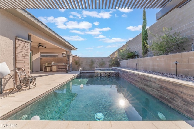 view of pool with a patio, an in ground hot tub, an outdoor kitchen, and ceiling fan