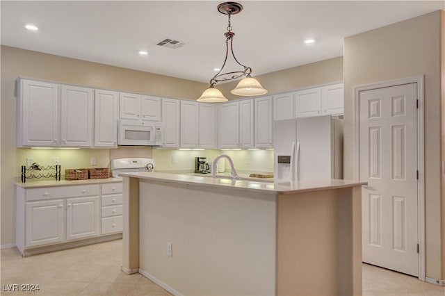 kitchen with white appliances, white cabinets, a center island with sink, hanging light fixtures, and light tile patterned floors