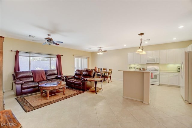 living room with light tile patterned floors, ceiling fan, and sink