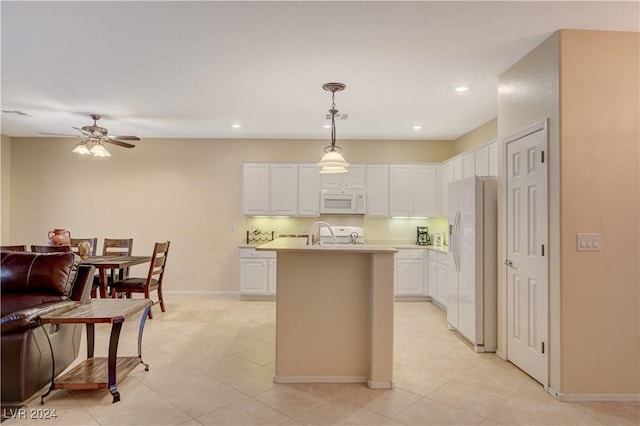 kitchen with white appliances, ceiling fan, pendant lighting, a center island with sink, and white cabinets