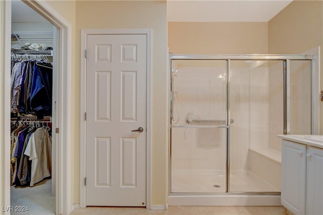 bathroom with tile patterned flooring, vanity, and an enclosed shower