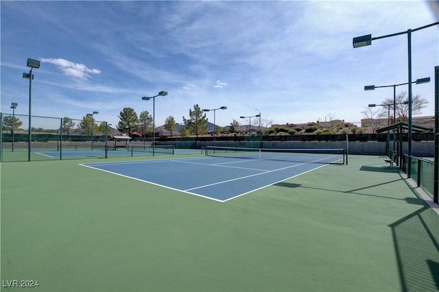 view of tennis court featuring basketball hoop