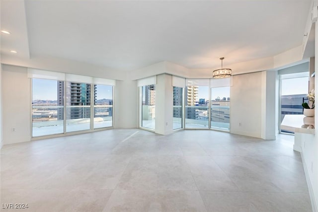 unfurnished room with a notable chandelier