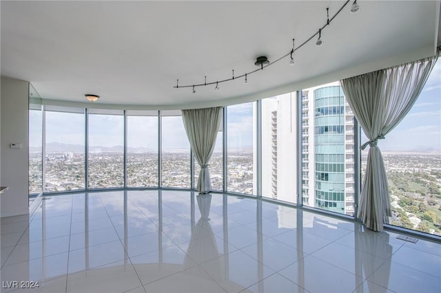 unfurnished room featuring light tile patterned flooring and a wall of windows