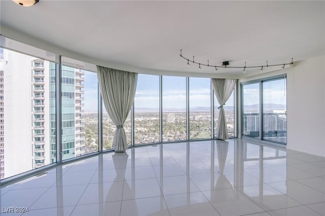 tiled spare room featuring floor to ceiling windows