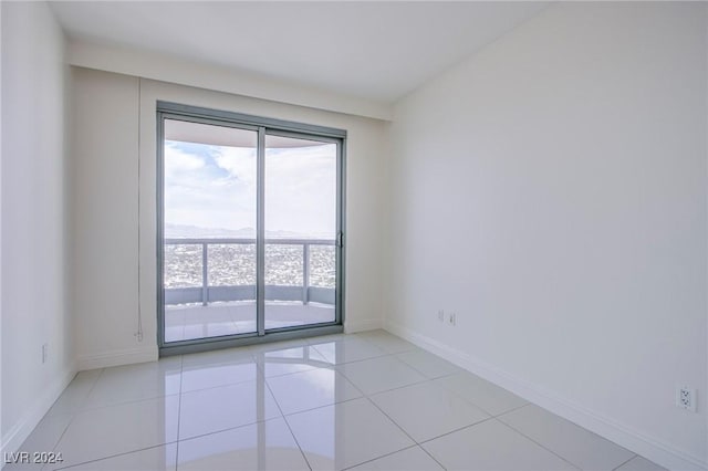 spare room featuring baseboards and light tile patterned floors