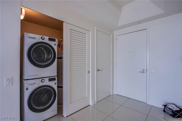 laundry area featuring light tile patterned floors and stacked washer / drying machine