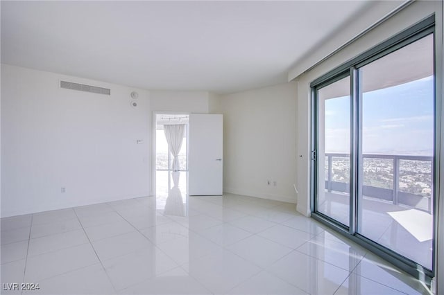 unfurnished room with light tile patterned floors and plenty of natural light