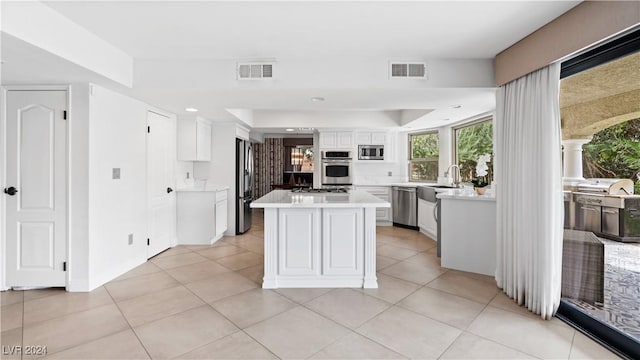 kitchen featuring white cabinets, sink, light tile patterned floors, and stainless steel appliances