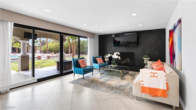 living room with light tile patterned floors and a large fireplace