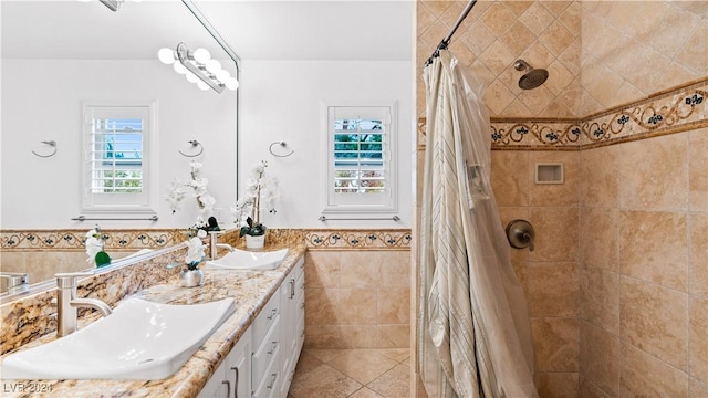 bathroom with tile patterned flooring, vanity, tile walls, and walk in shower