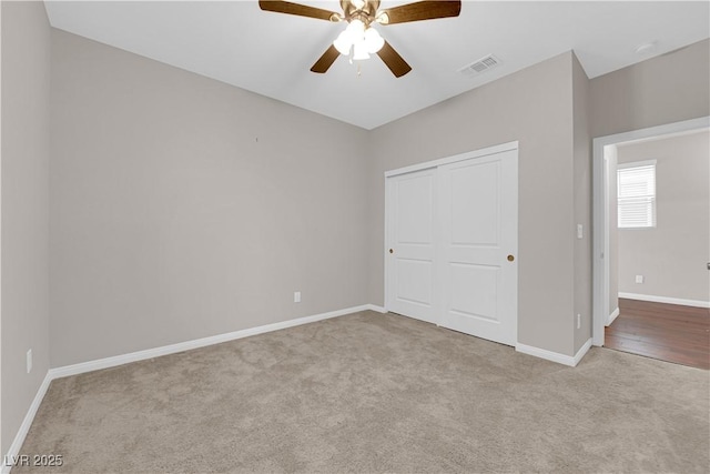 unfurnished bedroom with ceiling fan, visible vents, baseboards, a closet, and carpet