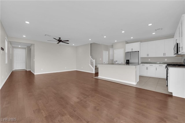 kitchen with appliances with stainless steel finishes, recessed lighting, a center island with sink, and a ceiling fan