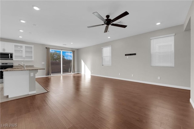 unfurnished living room with recessed lighting, visible vents, ceiling fan, wood finished floors, and baseboards