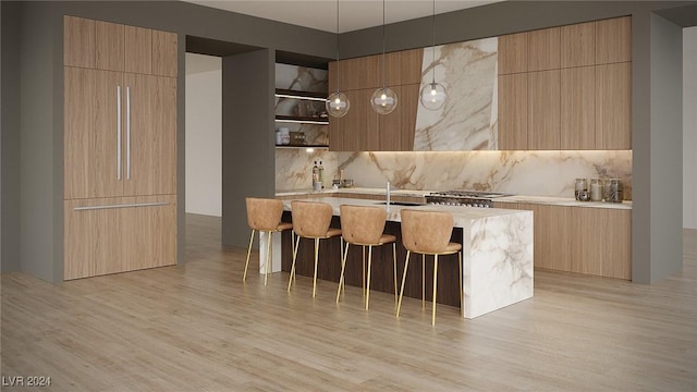 kitchen featuring light wood finished floors, modern cabinets, light countertops, and backsplash