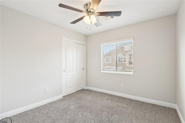 carpeted spare room featuring ceiling fan