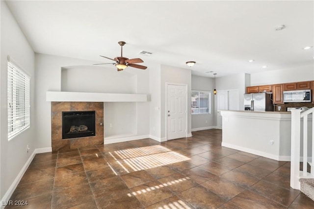 unfurnished living room featuring a fireplace and ceiling fan