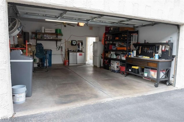 garage featuring a garage door opener, a workshop area, and white refrigerator