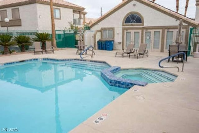 view of pool with a patio area and a hot tub