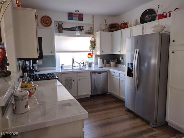 kitchen with appliances with stainless steel finishes, white cabinets, backsplash, sink, and dark hardwood / wood-style floors