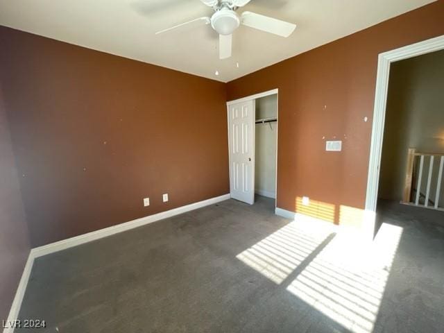 unfurnished bedroom featuring dark colored carpet, ceiling fan, and a closet