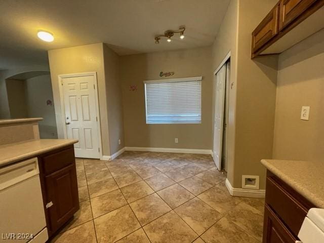 kitchen with light tile patterned floors and white dishwasher