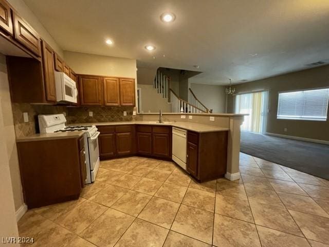 kitchen featuring sink, kitchen peninsula, white appliances, decorative backsplash, and light tile patterned floors