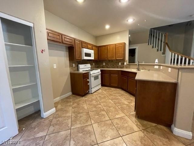 kitchen with sink, light tile patterned floors, white appliances, and backsplash