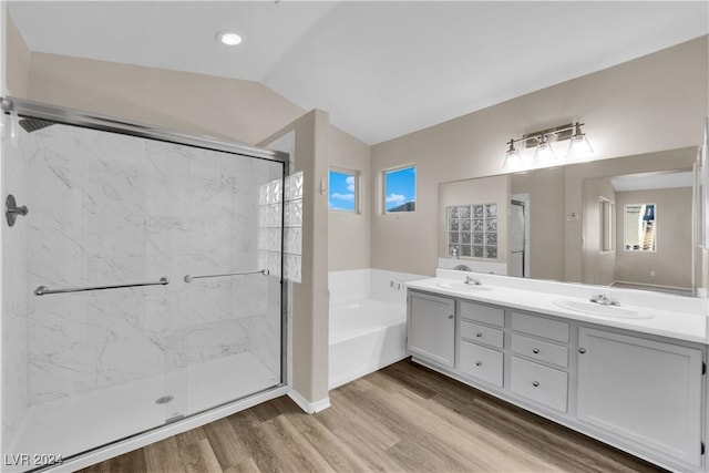 bathroom featuring vanity, wood-type flooring, independent shower and bath, and vaulted ceiling