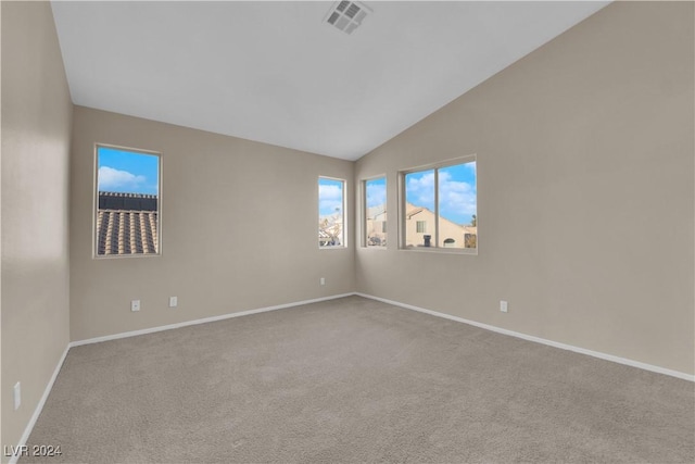 carpeted spare room featuring vaulted ceiling