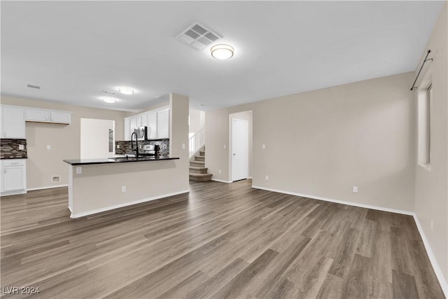 interior space featuring dark hardwood / wood-style flooring, tasteful backsplash, and white cabinetry