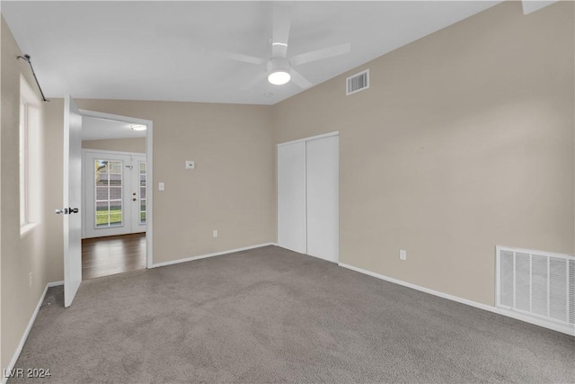 spare room featuring carpet, ceiling fan, and vaulted ceiling