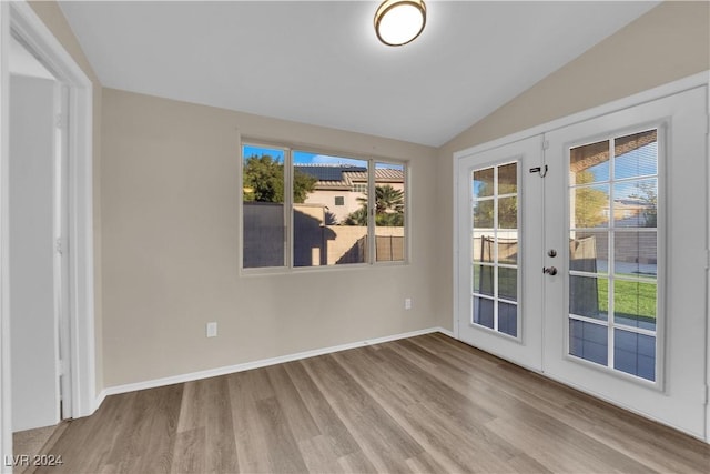 interior space with vaulted ceiling, light hardwood / wood-style flooring, and french doors