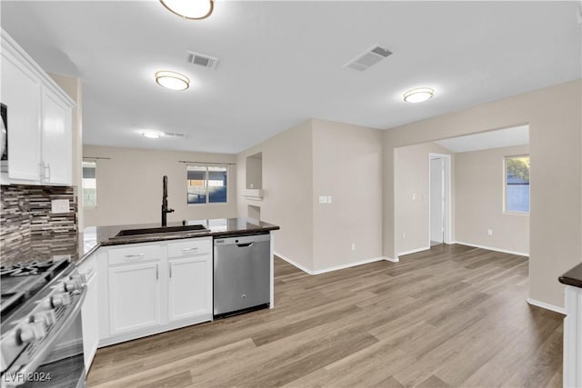 kitchen with white cabinetry, sink, stainless steel appliances, light hardwood / wood-style flooring, and kitchen peninsula