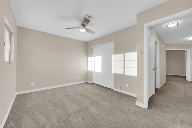 spare room with ceiling fan and light colored carpet