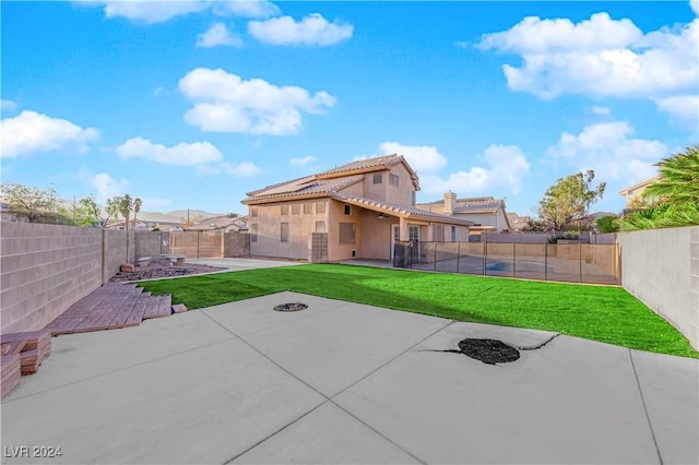 rear view of house with a patio area and a yard