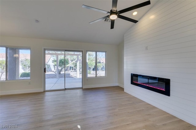 unfurnished living room featuring ceiling fan, a large fireplace, high vaulted ceiling, and light hardwood / wood-style flooring