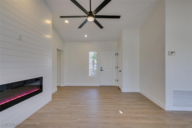 entrance foyer with ceiling fan, a fireplace, and light hardwood / wood-style flooring