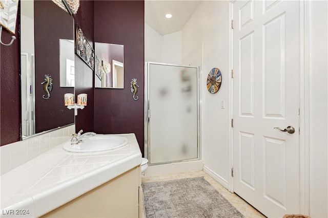 bathroom featuring tile patterned flooring, vanity, an enclosed shower, and toilet