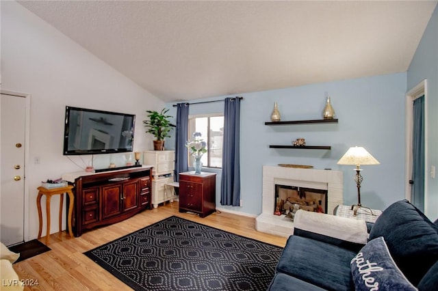 1701 E Katie Ave Unit 72, Las Vegas, NV 89119 - living room featuring vaulted ceiling, light wood-style floors, and a fireplace