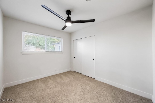 unfurnished bedroom with ceiling fan, a closet, and light colored carpet